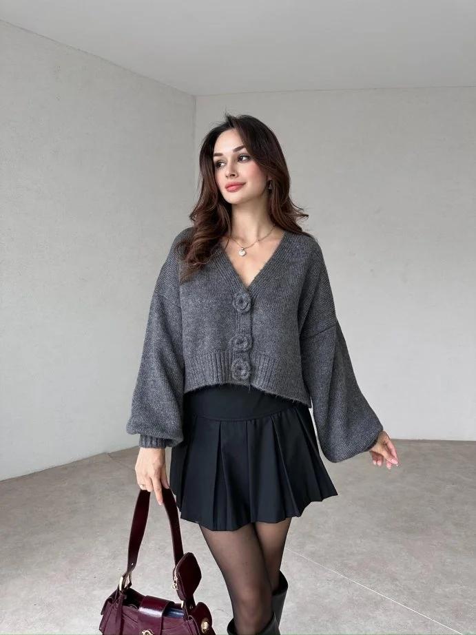 Cardigan gris en maille avec boutons floraux, parfait pour un style casual chic. 