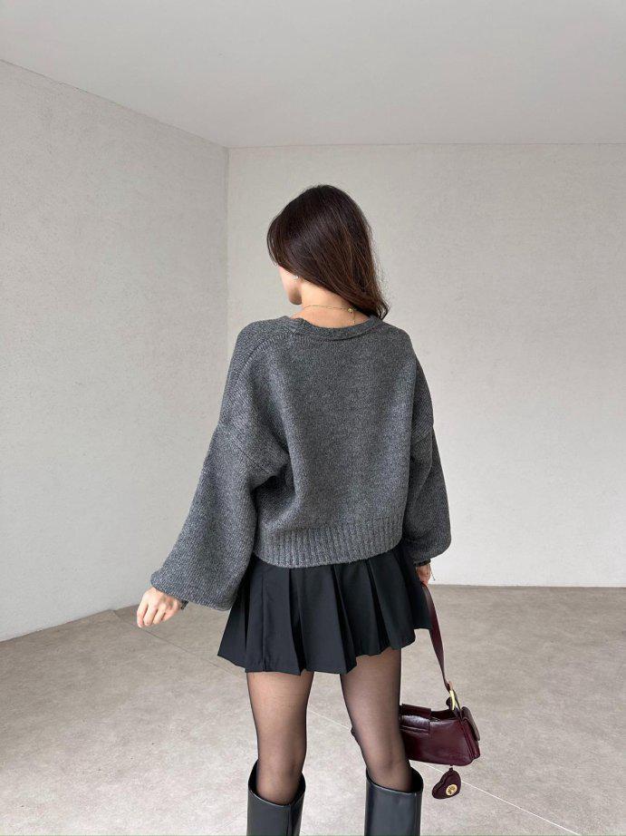 Cardigan gris en maille avec boutons floraux, parfait pour un style casual chic. 